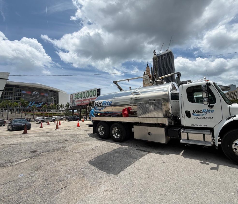 A VacRite vacuum tanker truck parked on a downtown Miami lot with the Kaseya Center and the city skyline behind it